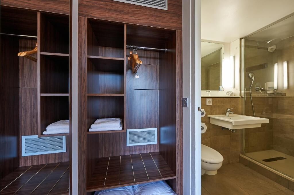 A modern bathroom with a walk-in shower, a toilet, and a vanity with a mirror.