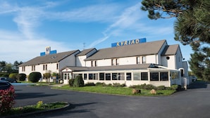 A two-story building with a sign reading "KYRIAK" on the roof. - Hôtel Kyriad Caen Sud - Ifs (Ifs)