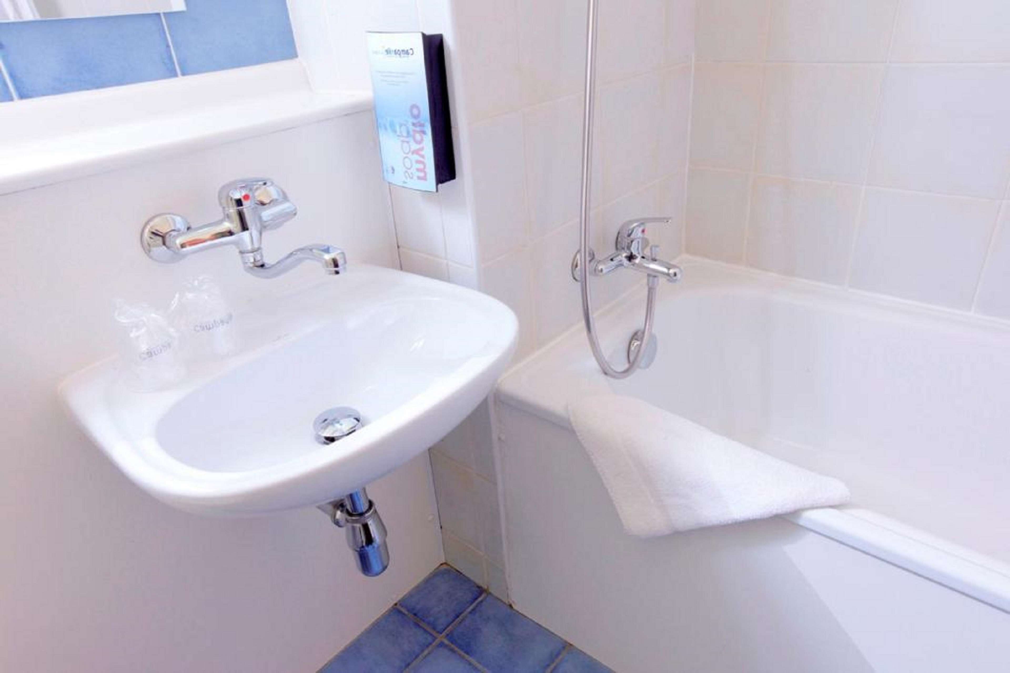 A bathroom with a white sink, a bathtub, and a towel rack.