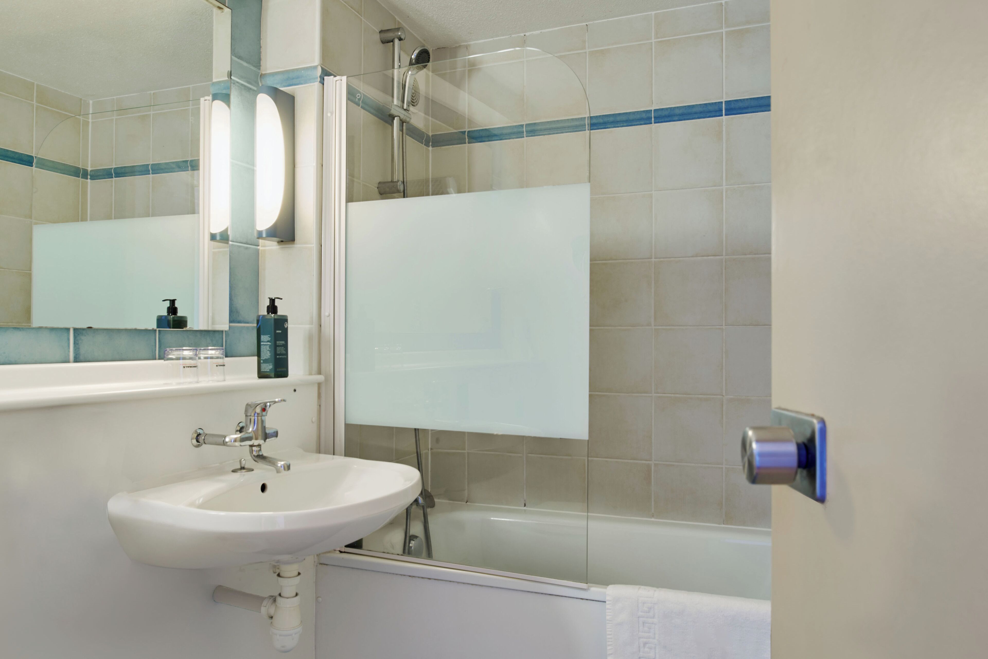Ein Badezimmer mit Waschbecken, Spiegel, Dusche und Badewanne.