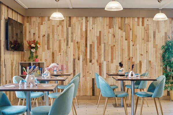 Un restaurante con paredes de madera, sillas azules y mesas dispuestas para comer.
