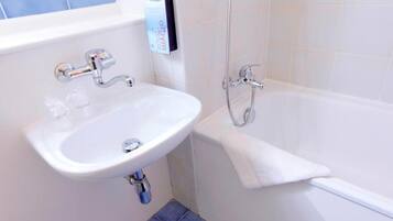 Une salle de bain avec un lavabo blanc, une baignoire et une douche.