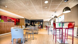 Un interior de restaurante moderno con zona de bar, diversas opciones de asientos y un menú a la vista.