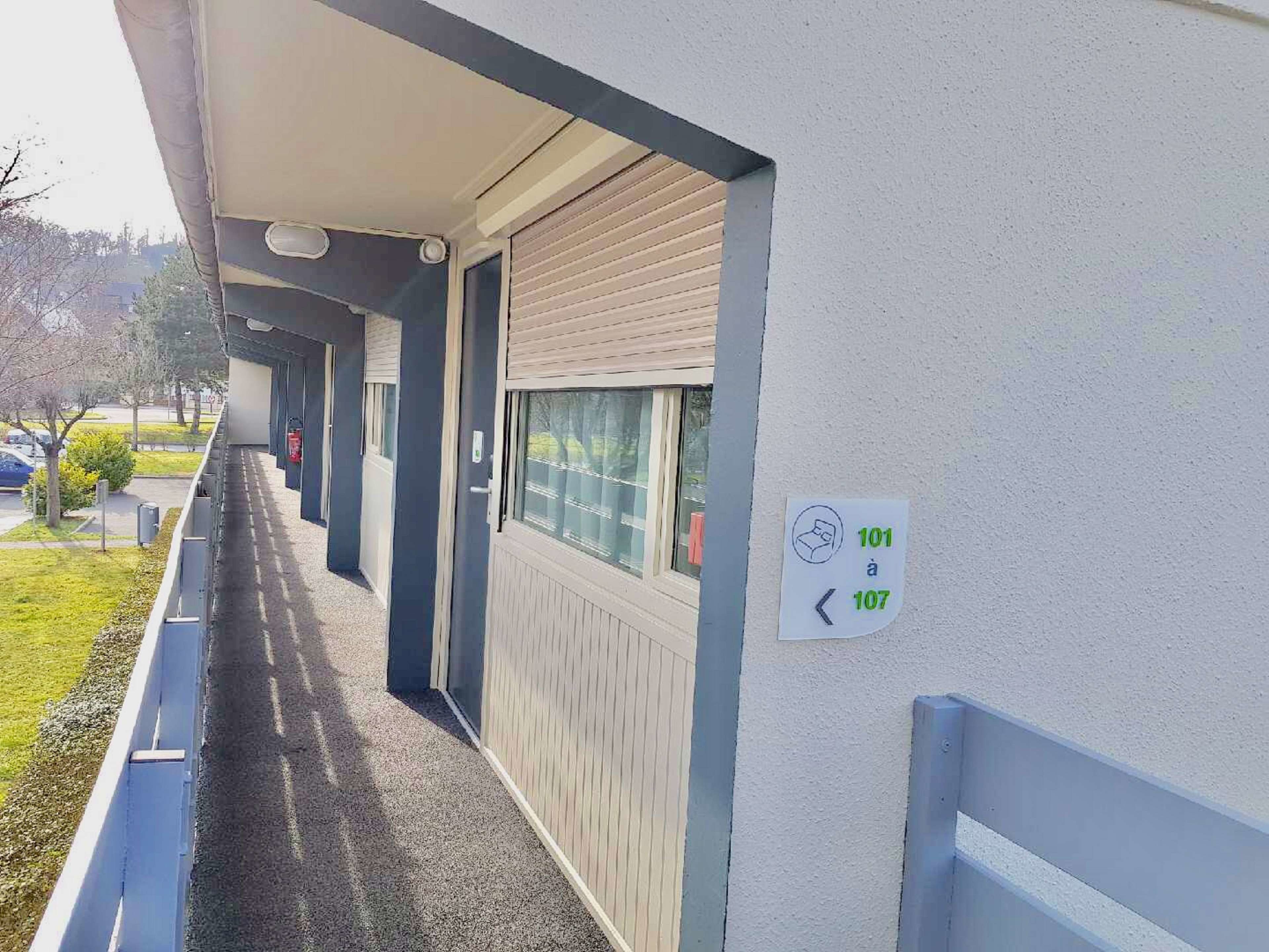 Corredor com placa indicando os quartos 101 e 107.