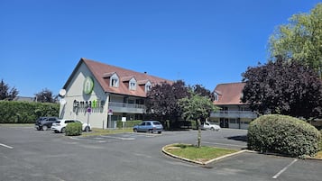 A commercial building with a sign reading "campanile" and a parking lot with several cars.