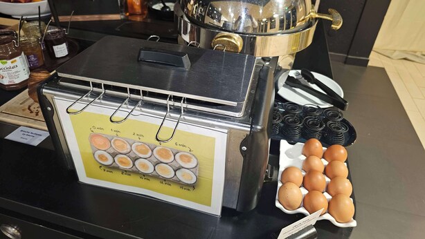 Estación de desayuno con temporizador, huevos y acompañamientos.