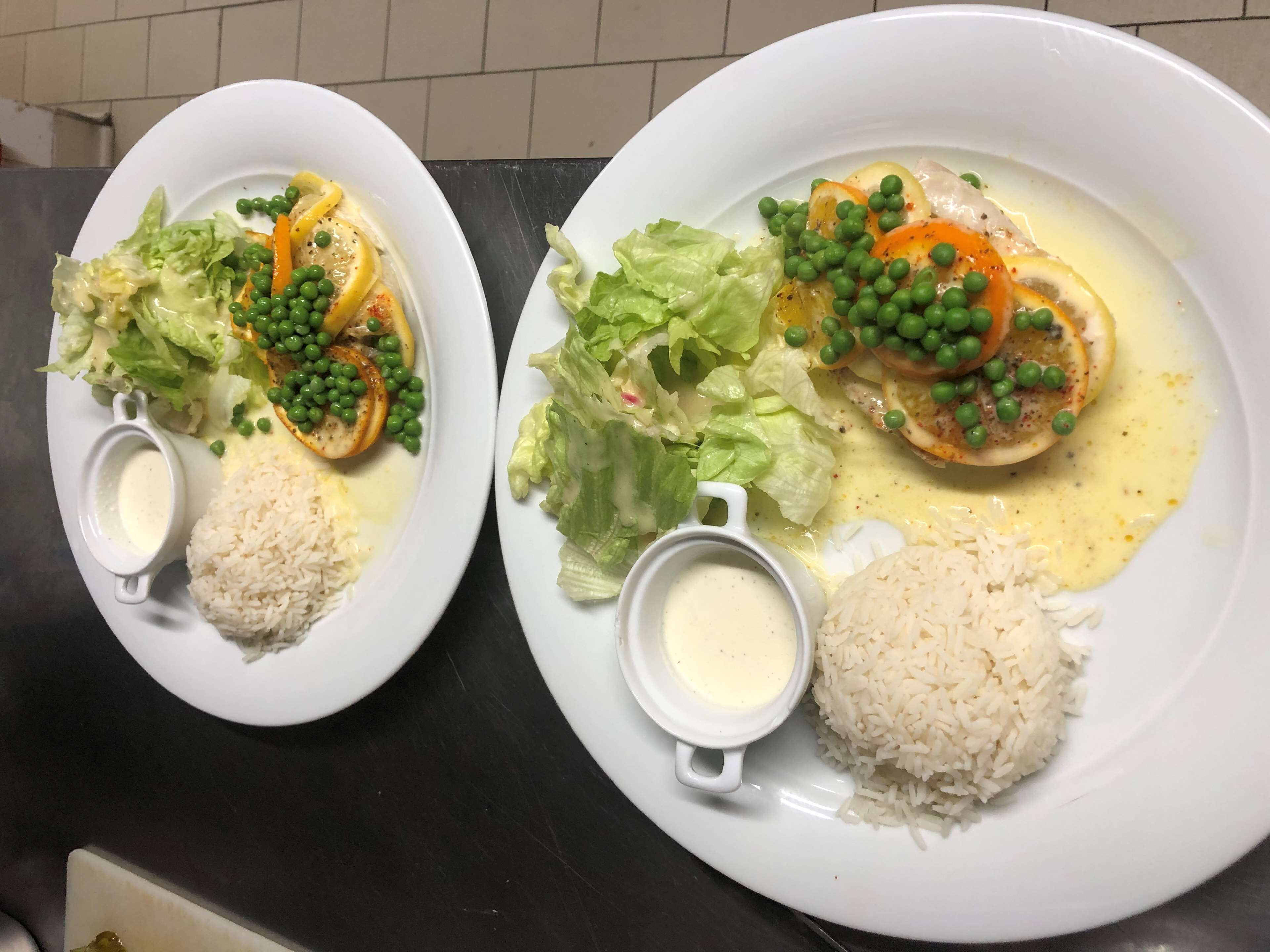 Deux assiettes de nourriture composées de riz, de légumes et d’une sauce crémeuse.