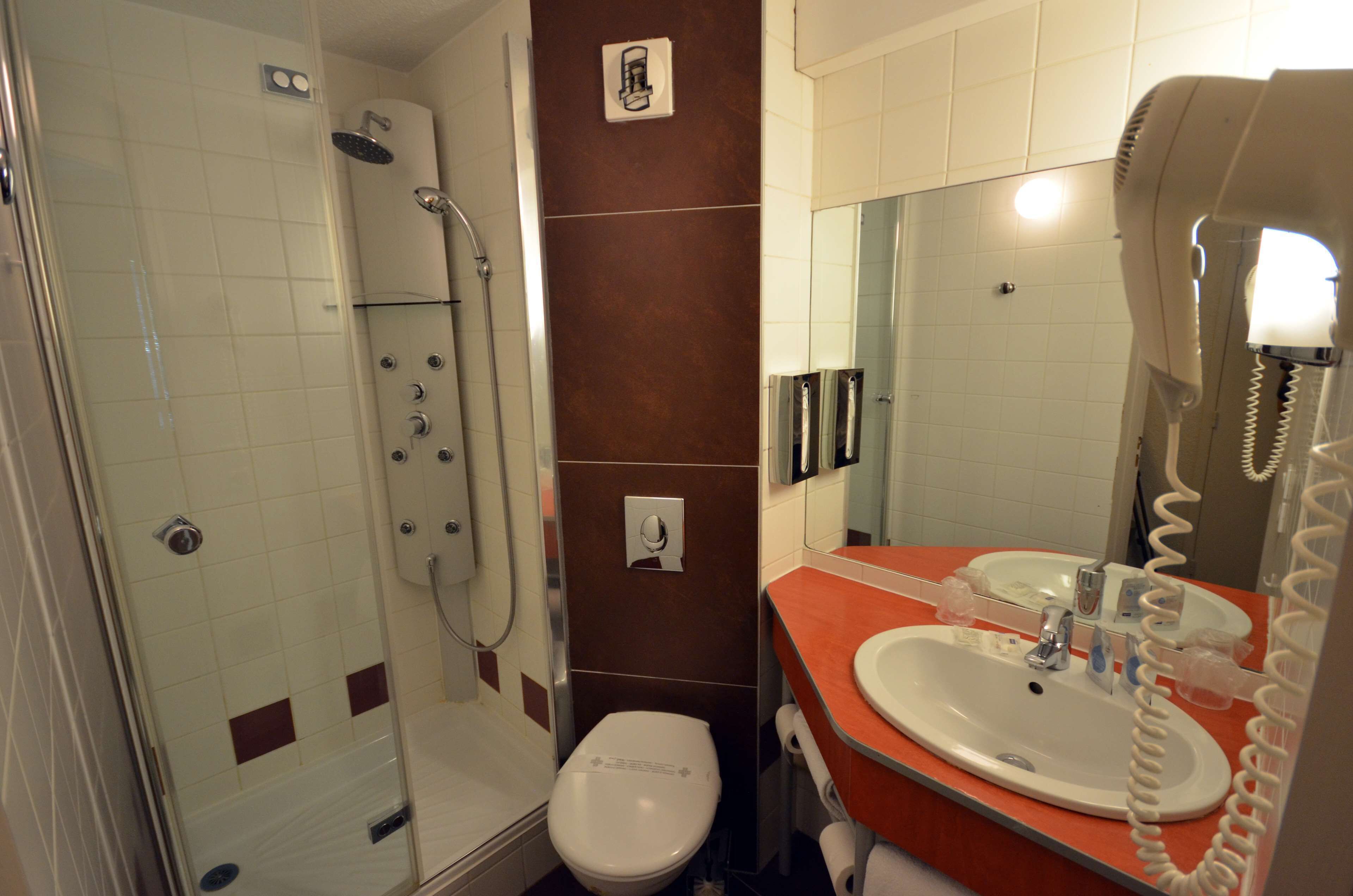 Un baño con ducha, inodoro y lavamanos.