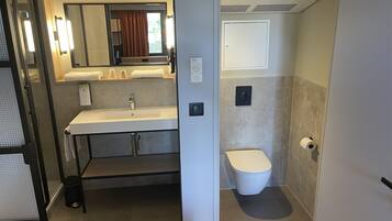 Un baño pequeño con lavamanos, espejo e inodoro.