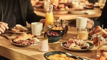 En morgenmadsbuffet med et udvalg af mad og drikkevarer.