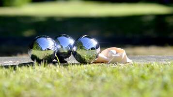Three glass spheres on a wooden surface with grass in the foreground and a blurred park background.