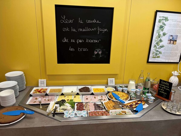 Un bufé con diferentes alimentos y una pizarra con un mensaje en francés.