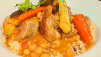 Prato de ensopado de frango com legumes e cuscuz.