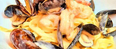 Un plato de pasta con mejillones y camarones.