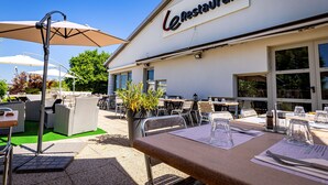 Un restaurante al aire libre con mesas, sillas y sombrillas.