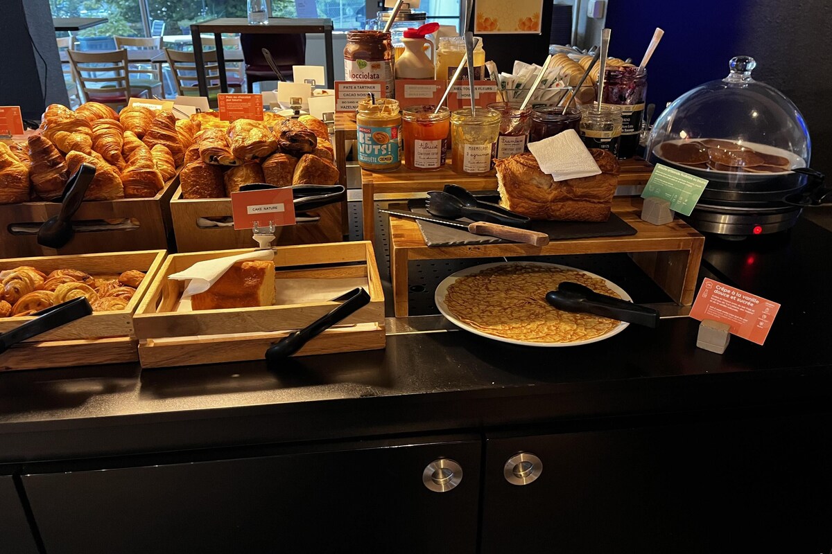 Un bufé de desayuno con diversos pasteles, mermeladas y una estación de comida caliente.