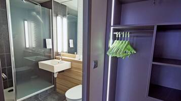 Une salle de bain moderne avec une douche à parois de verre, un lavabo blanc et des toilettes.
