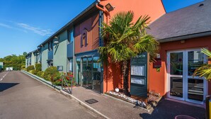 Una hilera de edificios coloridos con una recepción, un restaurante y un cartel que indica zona de recepción.
