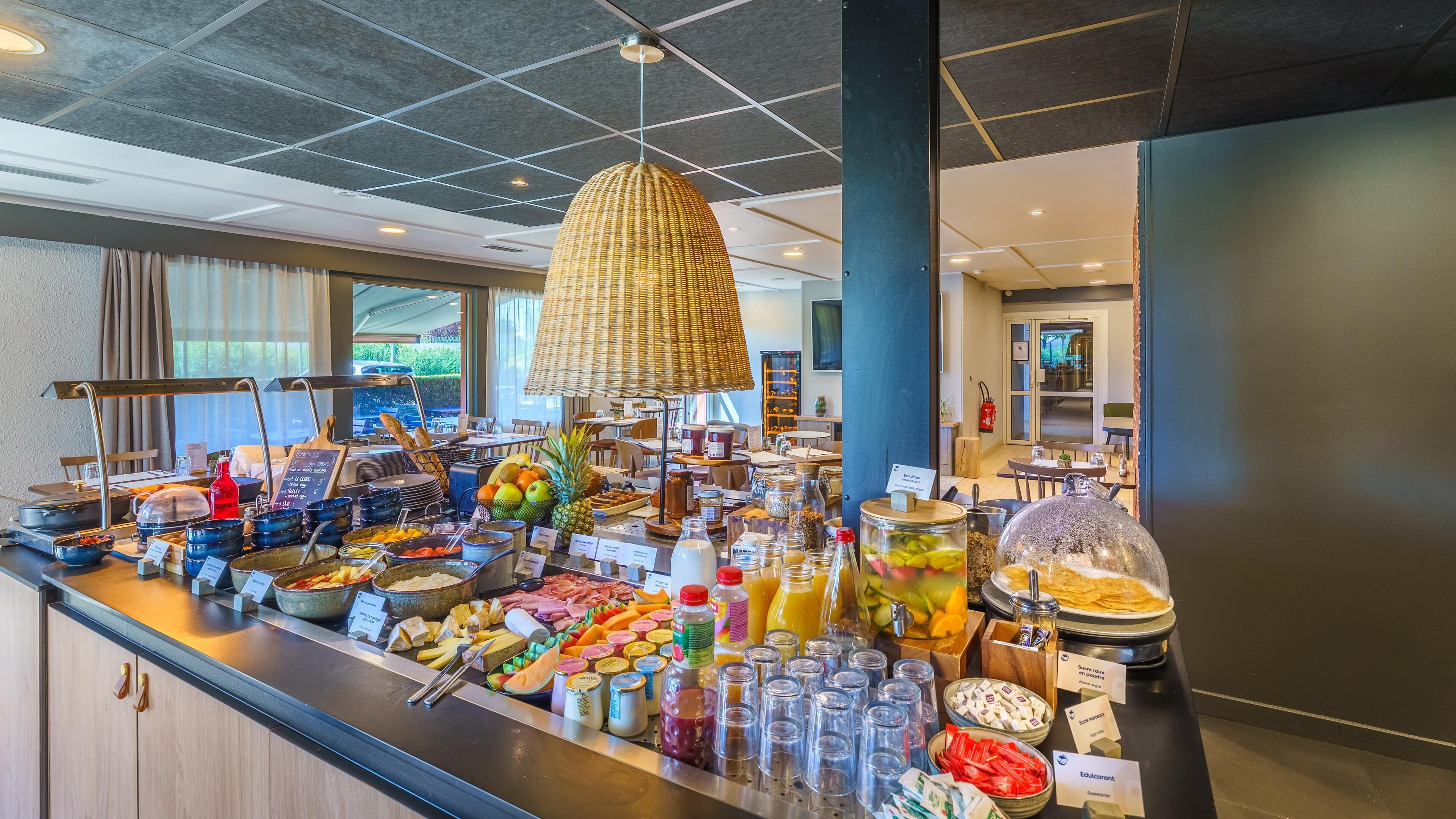 A buffet area with a variety of food items, including fruits, cheeses, and beverages.