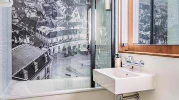 Un baño con bañera, lavabo y espejo.