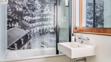 Un baño con bañera, lavabo y espejo.