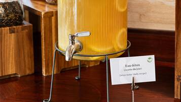 Un tarro de vidrio con un grifo, etiquetado 'Eau détox', sobre una mesa de madera.