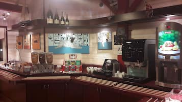 Zona de bar con mostrador, diversas bebidas y una pantalla digital con el menú.