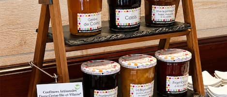 Un expositor de madera con botes de mermeladas artesanales.