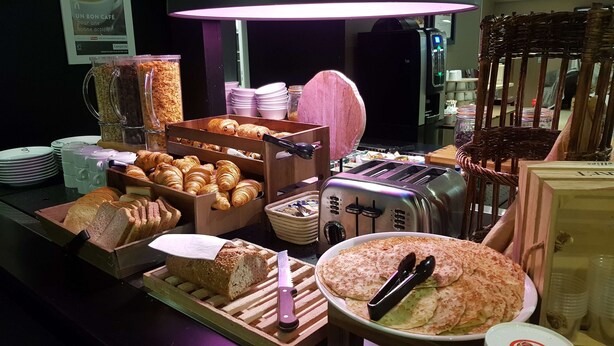 A breakfast buffet with various breads, pastries, and a toaster. - Hotel Campanile Saint Etienne Est - Saint Chamond (Saint-Chamond)