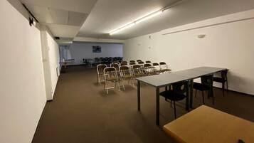 Un salón de conferencias con una larga mesa, varias sillas y una mesa más pequeña.