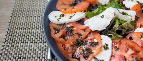 A plate of Caprese salad with tomatoes, mozzarella, and basil.