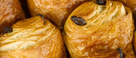 Primer plano de una variedad de pasteles, probablemente croissants, con capas visibles y pasas.