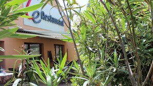 A restaurant with a sign, surrounded by greenery. - Hotel Campanile Grenoble Nord - Moirans (Moirans)