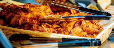 A basket of food items including grilled meat and pastries.