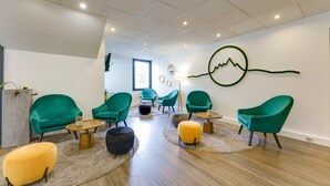 Un espace détente moderne avec des fauteuils turquoise, une table basse en bois et un tapis.