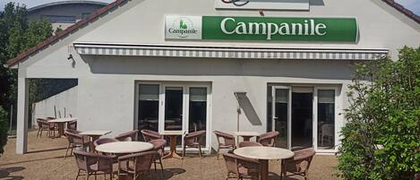 Un ristorante chiamato Campanile con posti a sedere all'aperto e una veranda coperta.