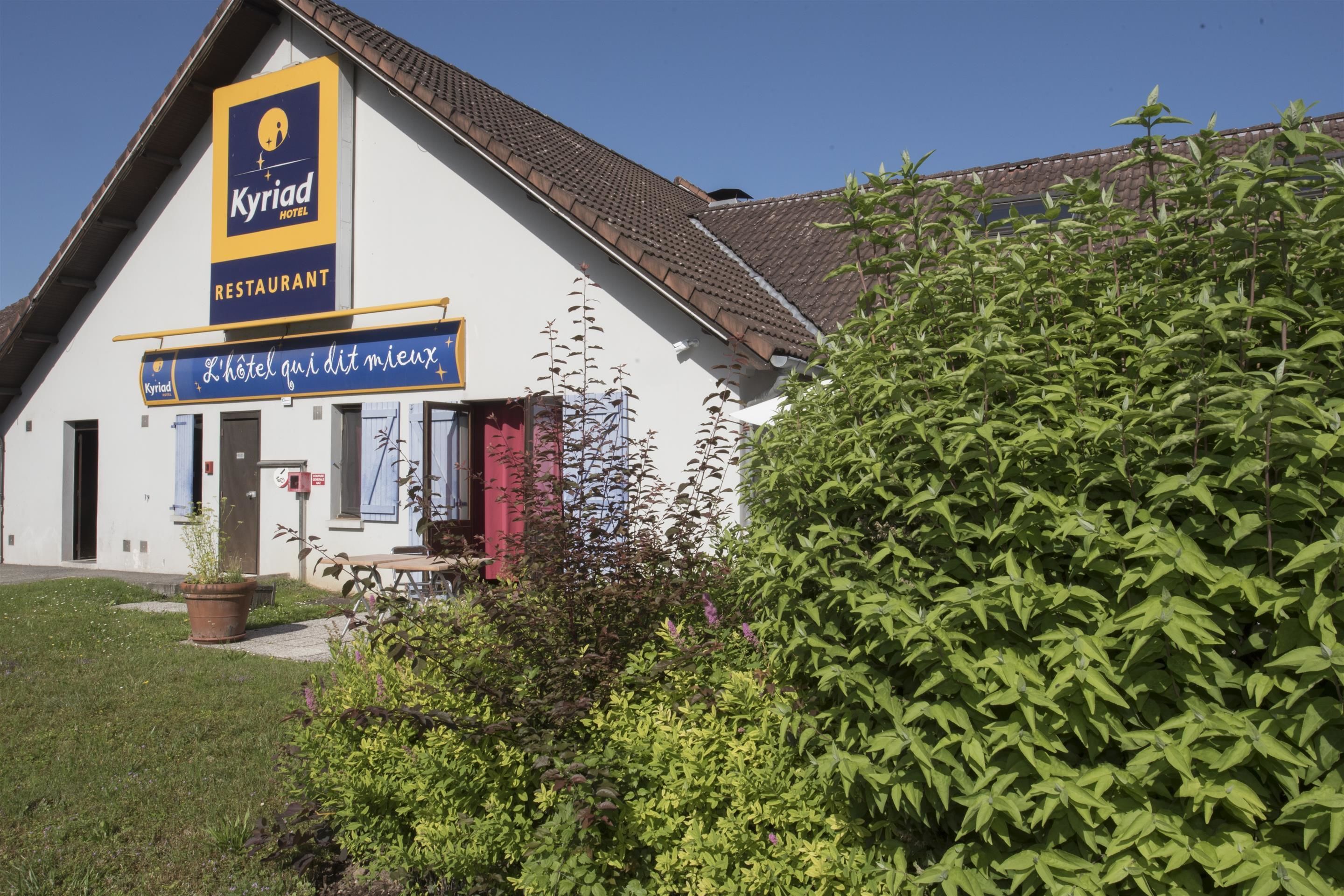 A building with a sign for 'Kyriad Hotel Restaurant' and a slogan 'L'hôtel qui dit mieux'.