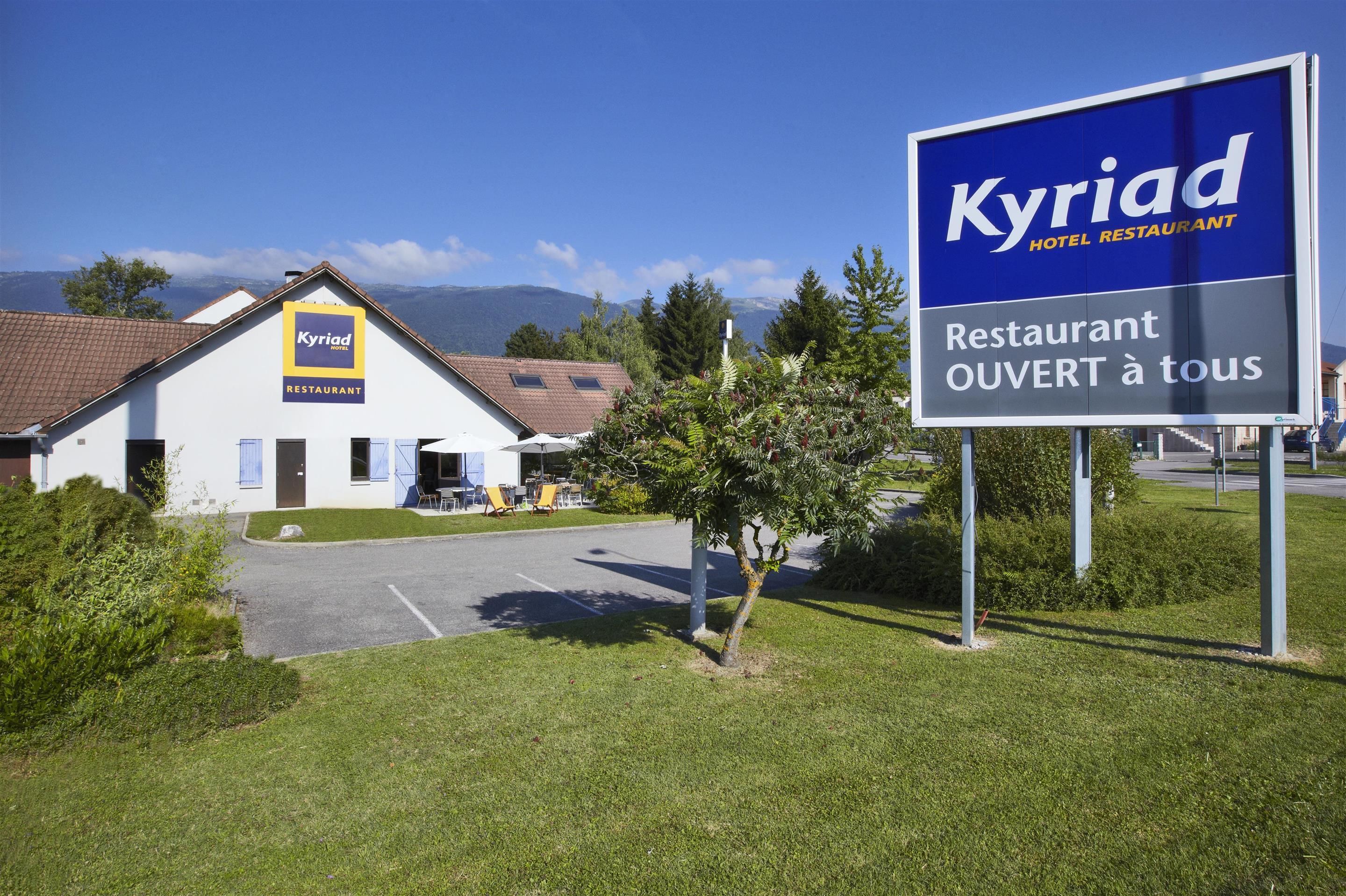 A building with a sign that reads "Kyriad HOTEL RESTAURANT" and "RESTAURANT OUVERT à tous".