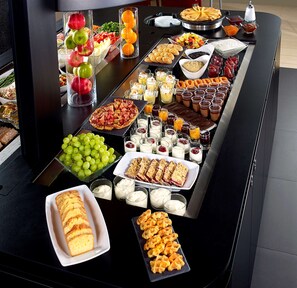 A buffet table with various food items including fruits, pastries, and desserts. - Kyriad Nancy Ouest - Laxou Zenith (Maxeville)