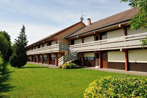 A two-story building with a covered walkway and a staircase leading to the upper floor.
