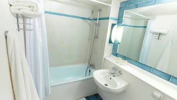A bathroom with a bathtub, a sink, and a mirror.