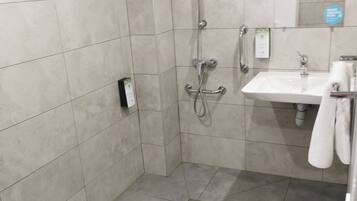 Une salle de bain moderne avec une douche, un lavabo et un miroir.