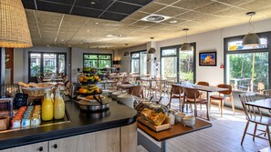 A breakfast buffet with various food items and a fruit display.