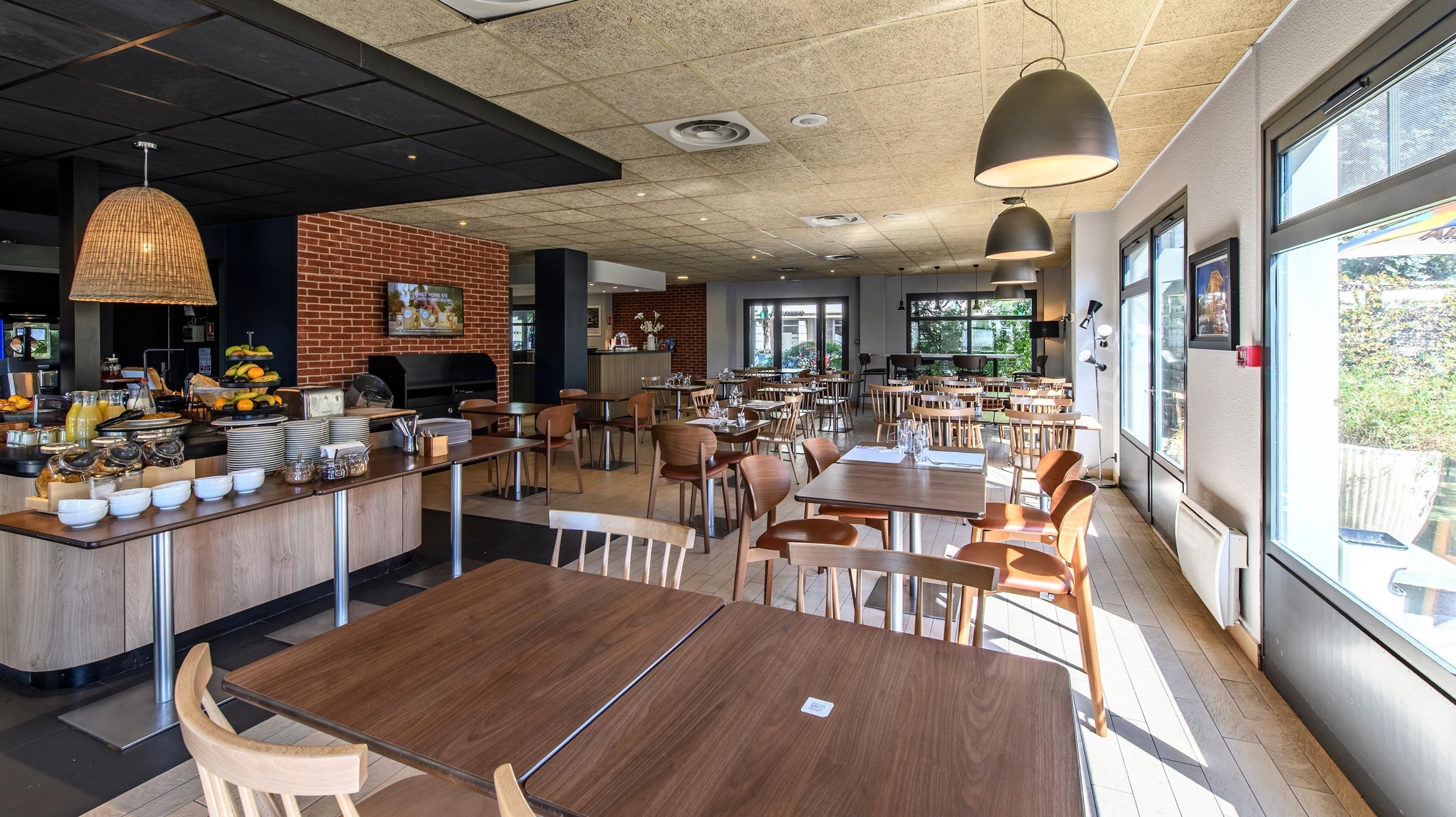 A spacious cafe with a brick wall, a buffet counter, and ample seating.