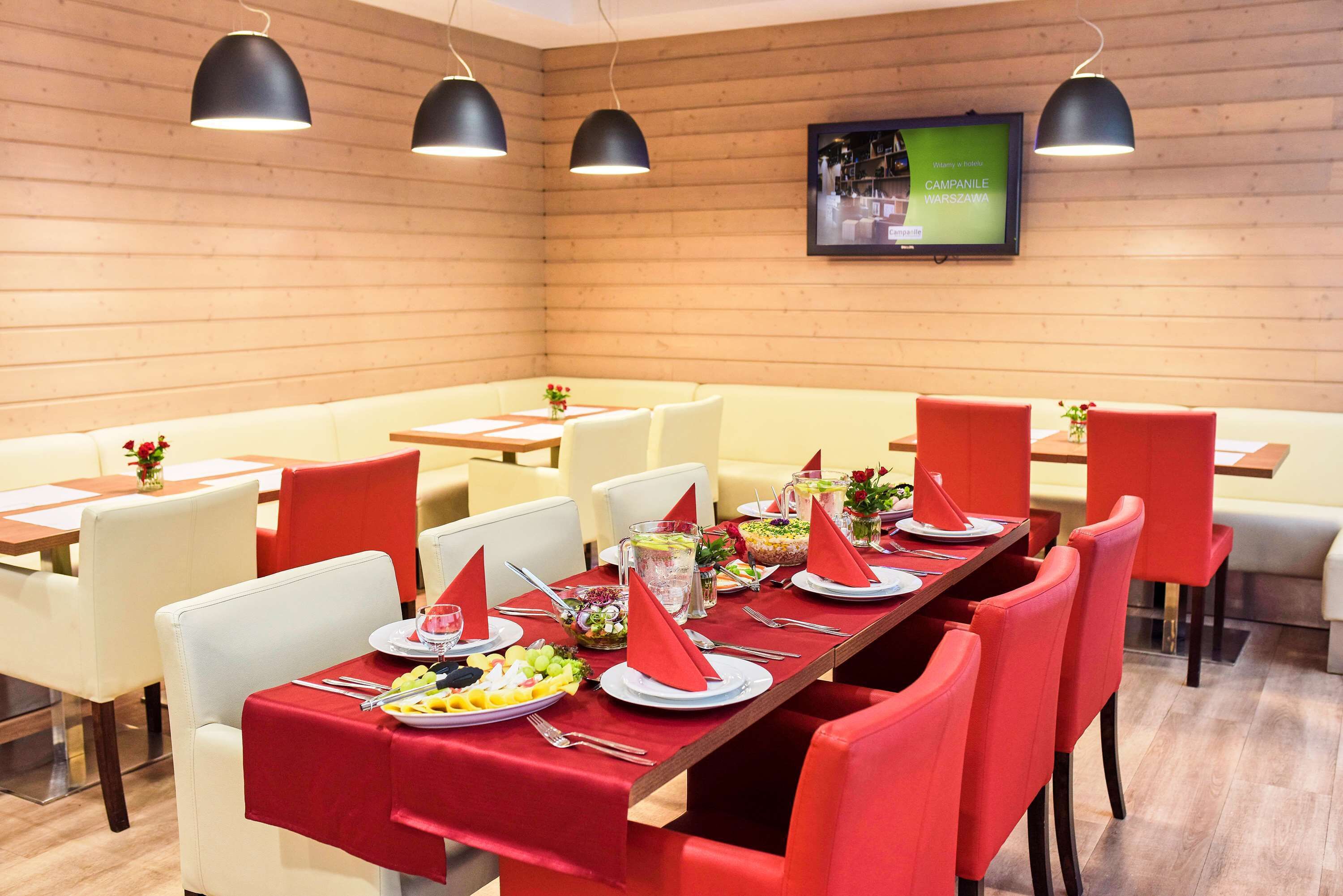 A dining area with a long table set for a meal, surrounded by chairs.