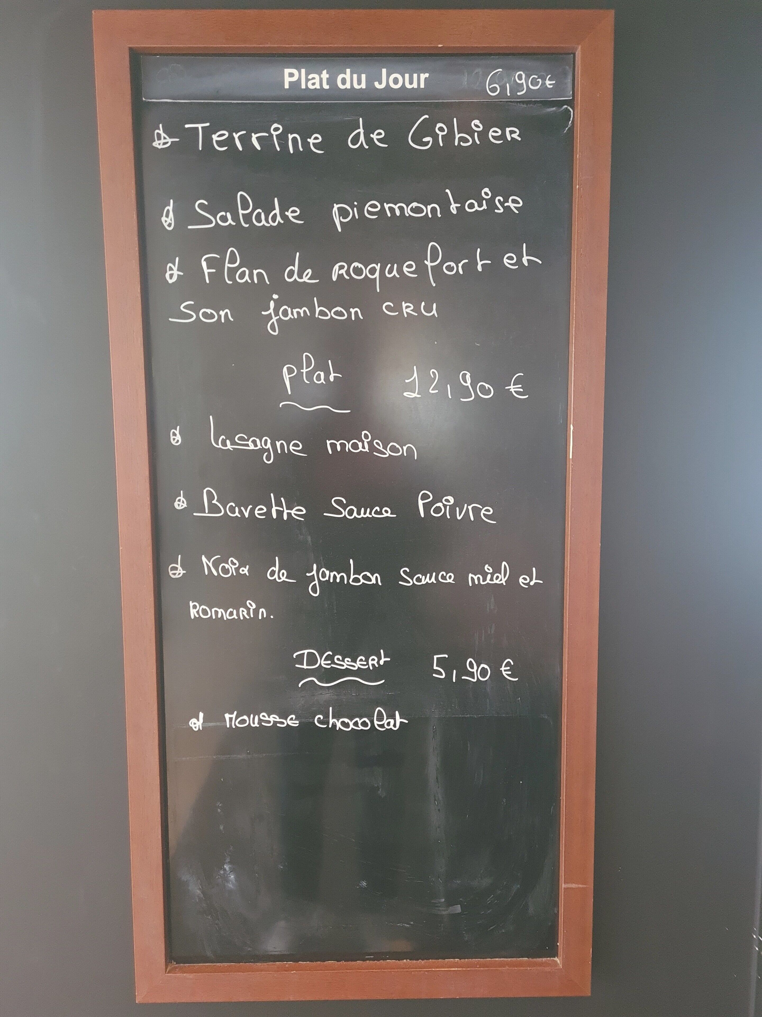 Un tableau noir affiche la liste des plats et les prix du petit-déjeuner.