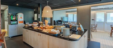 A breakfast bar with various food items, a coffee machine, and a toaster.