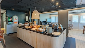 A breakfast bar with various food items, a coffee machine, and a toaster.