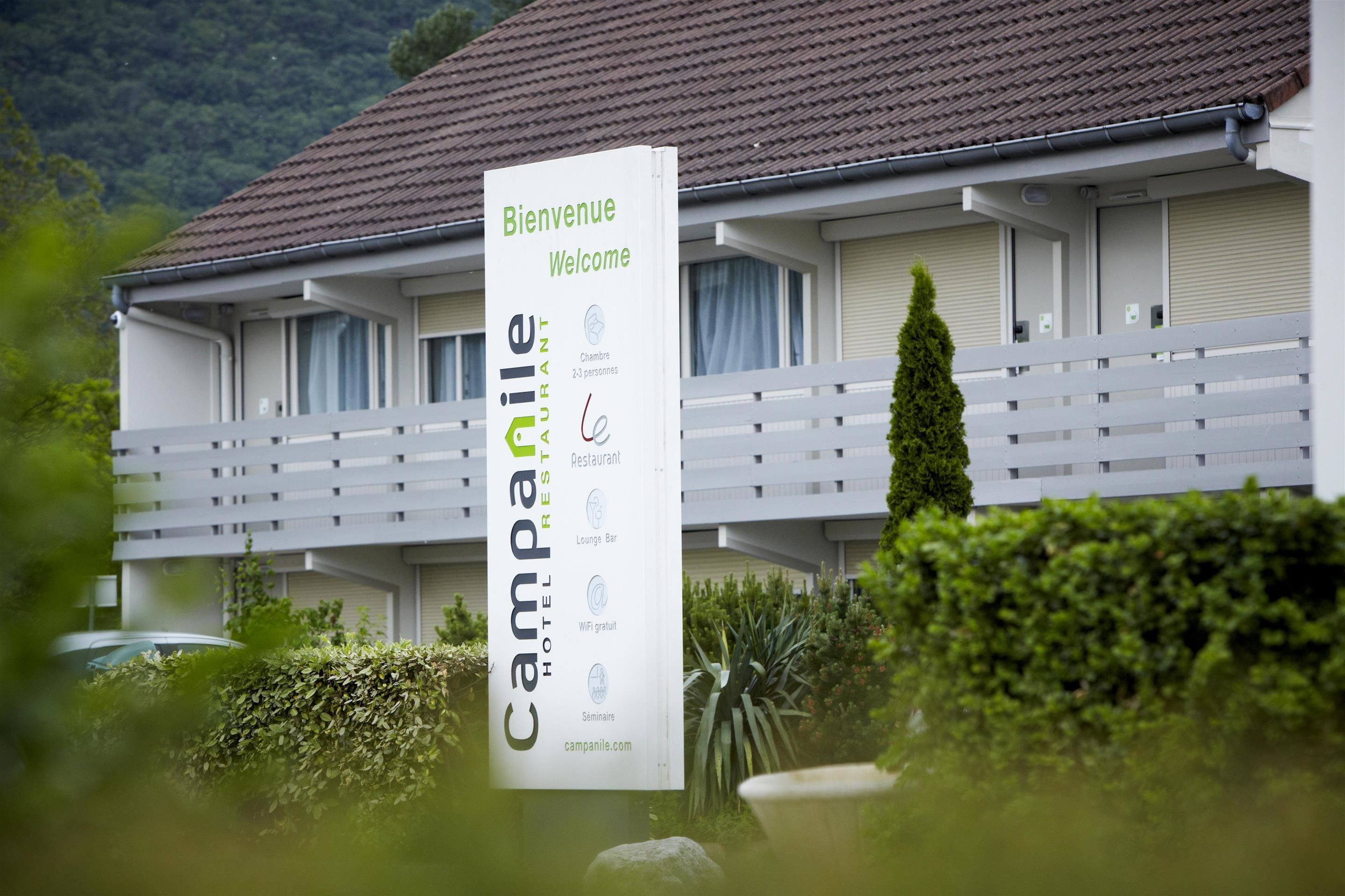 A hotel sign with "Bienvenue Welcome" and "Campanile Hotel Restaurant" text, indicating a welcoming entrance and a restaurant.