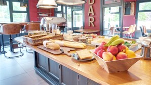 A breakfast bar with bread, pastries, and fruit. - Kyriad Lille Est - Hem (Hem)